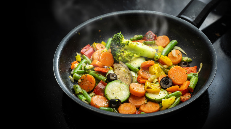 Zucchini, carrots, broccoli, green beans, and other vegetables in a pan