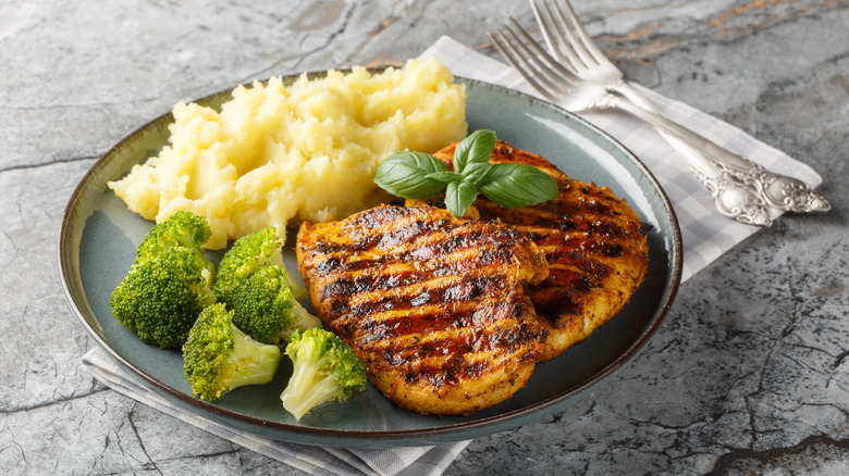 Fluffy mashed potatoes on a plate with chicken and broccoli