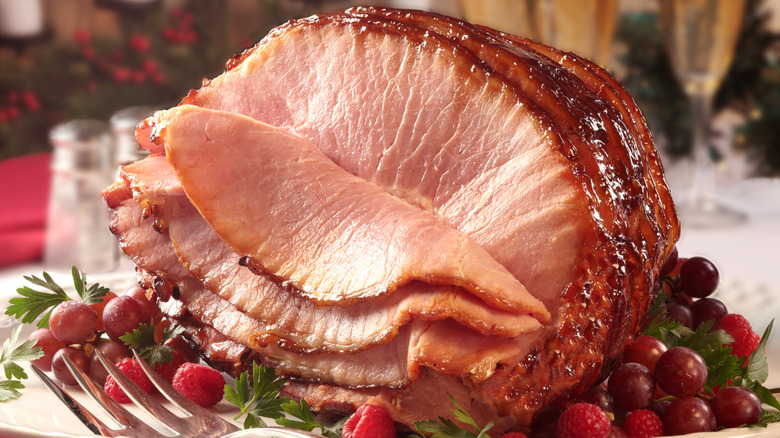 Spiral ham on plate with raspberries and grapes