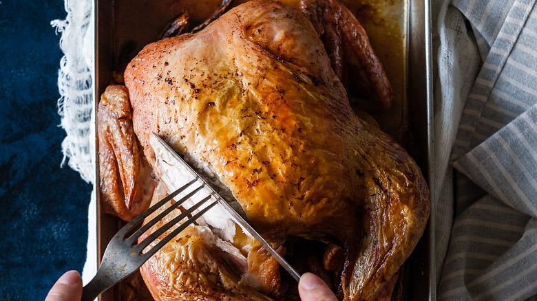 roasted whole chicken being carved