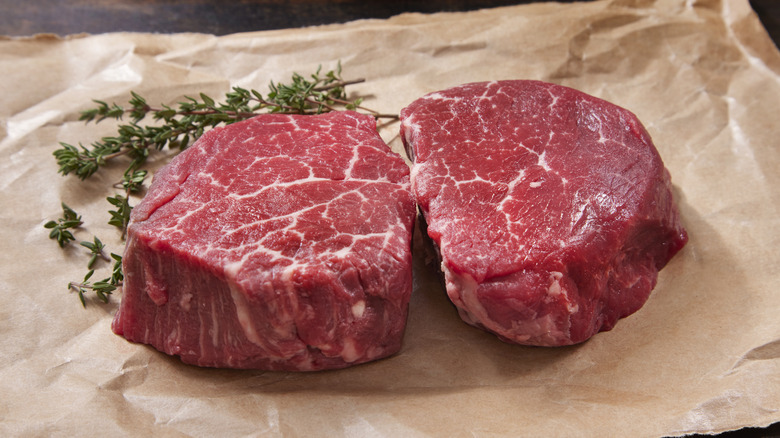 Raw filet mignons on table