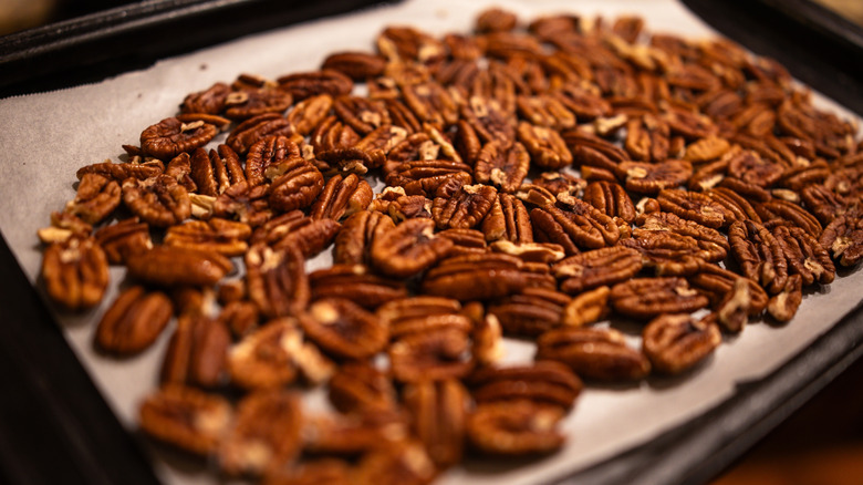Roasted pecans on a sheet tray close-up