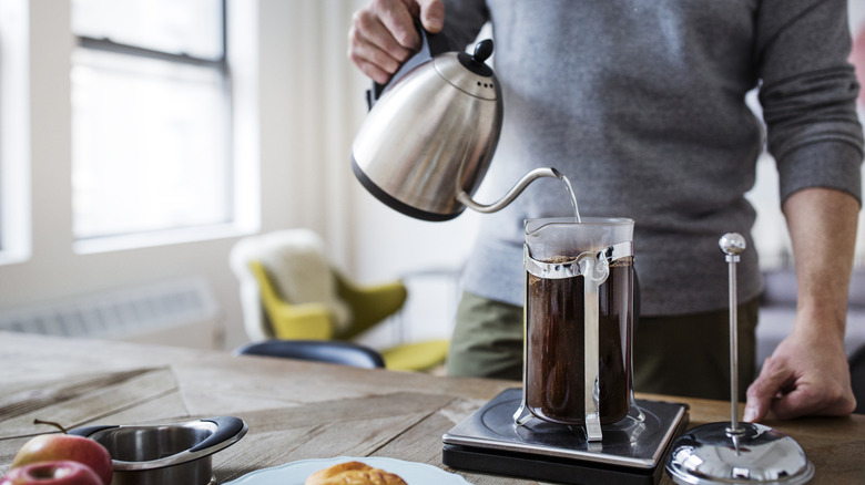 A person filling a French press
