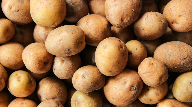 Raw potatoes stacked erratically on top of each other.