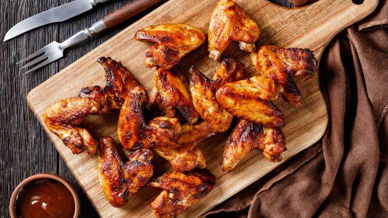 Chicken wings are arranged on a wooden board and photographed from above.
