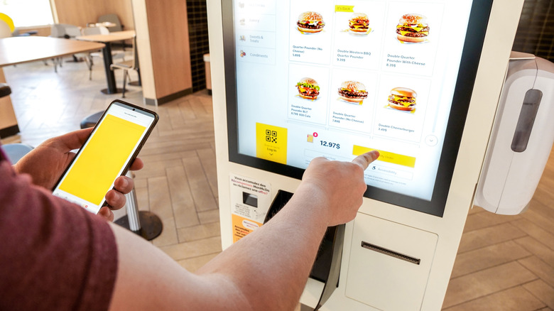Person ordering food at McDonald's kiosk