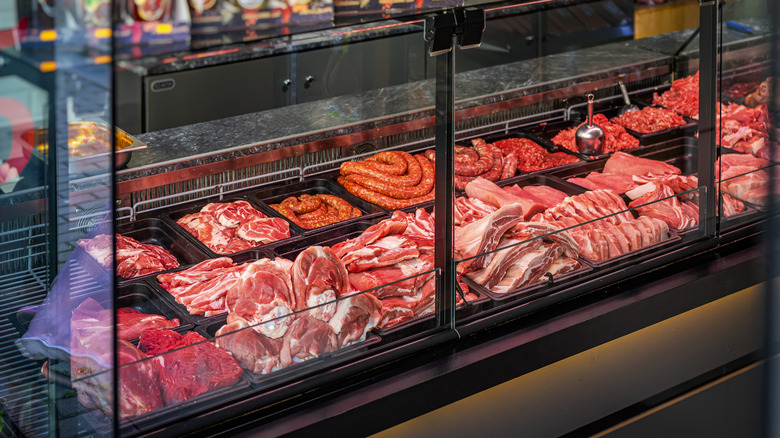 A variety or red meat options inside a glass case at a butcher shop