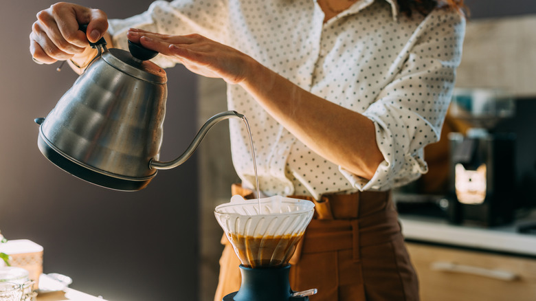 Woman pouring wanter in pour-over coffee maker