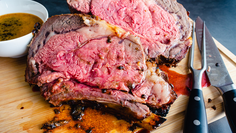 A prime rib is sliced on a board