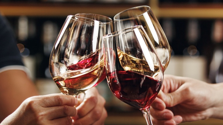 Four friends toasting with red wine