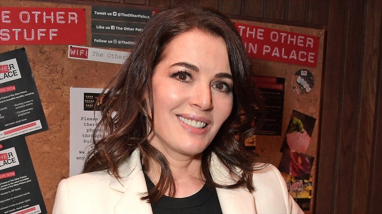 Close-up of Nigella Lawson smiling in a black crew neck shirt and cream-colored blazer