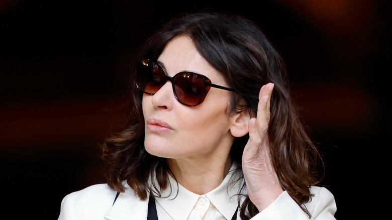 Nigella Lawson wearing sunglasses and holding hand up near her face