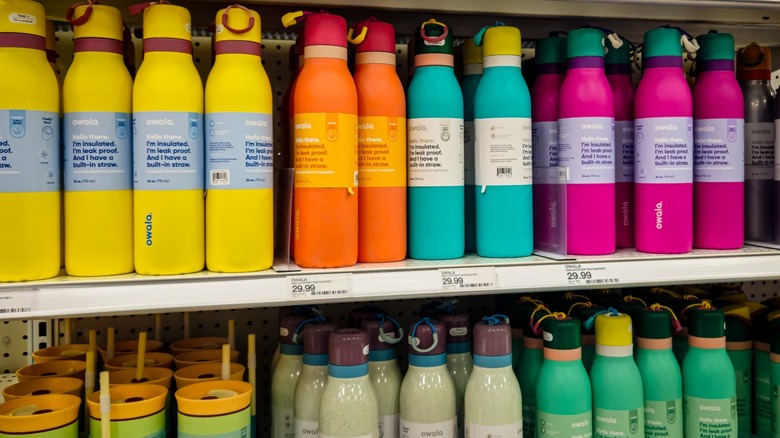 Owala water bottles in various colors on store shelves.