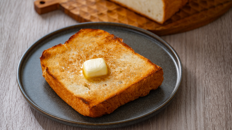 toast and pat of butter on a black plate