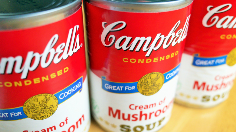Cans of Campbell's Cream of Mushroom soup on a shelf.