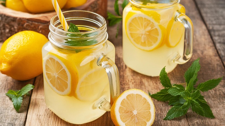 lemonade in glass with ripe lemons