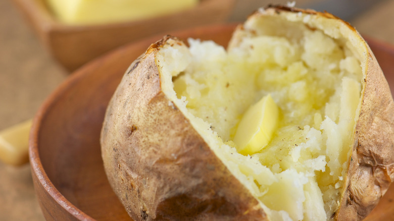A simple baked potato sliced in half with melted butter