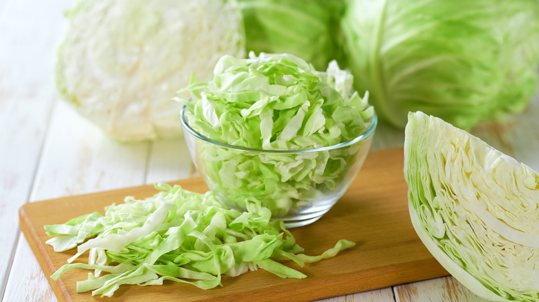 Raw whole, quartered, and shredded cabbage.