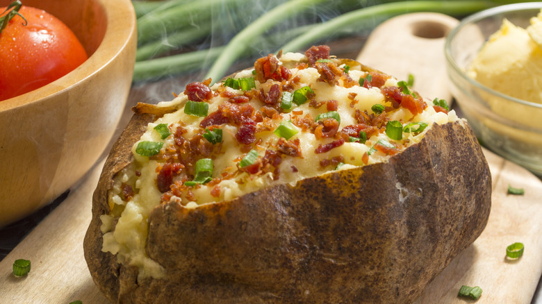 fresh hot baked potato with bacon bits and chives