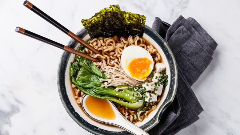 A bowl of ramen with bok choy and soft-boiled egg yolk.