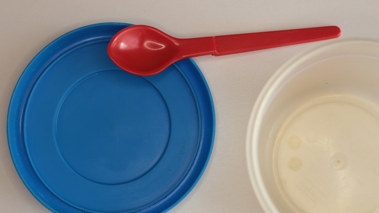 Red spoon on a blue plastic container lid