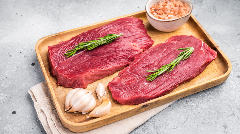 raw ostrich steaks on cutting board