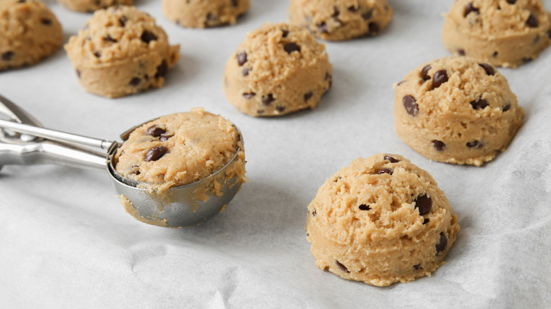 chocolate chip cookie dough scooped onto a baking sheet