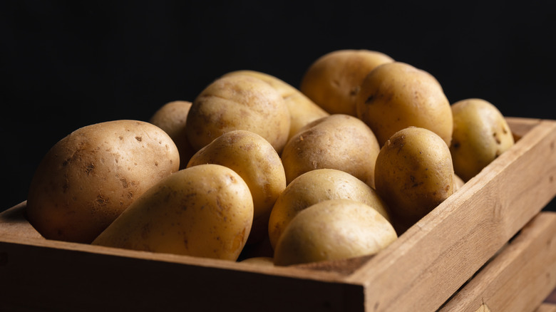 A wooden crate of potatoes