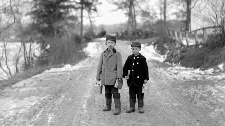Two young boys with lunch pails on the way to school