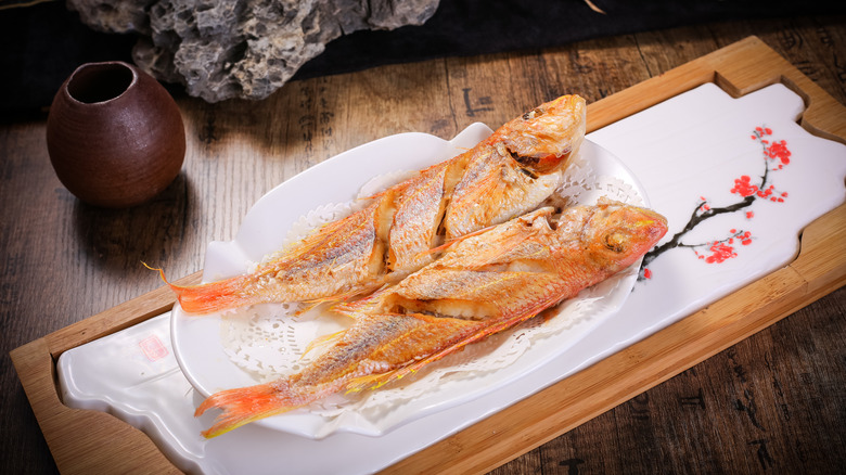 Two fried fish on a plate at an Asian restaurant