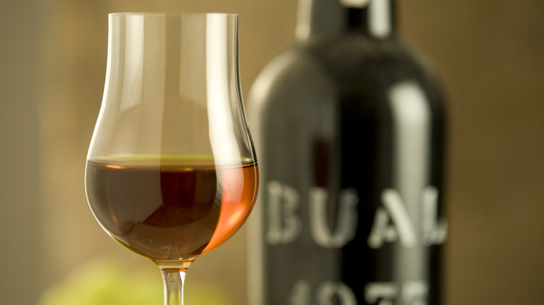 A glass of port in front of the port bottle