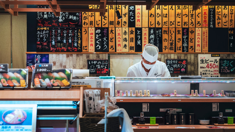 A sushi chef working behind a counter at a sushi restaurant in Japan