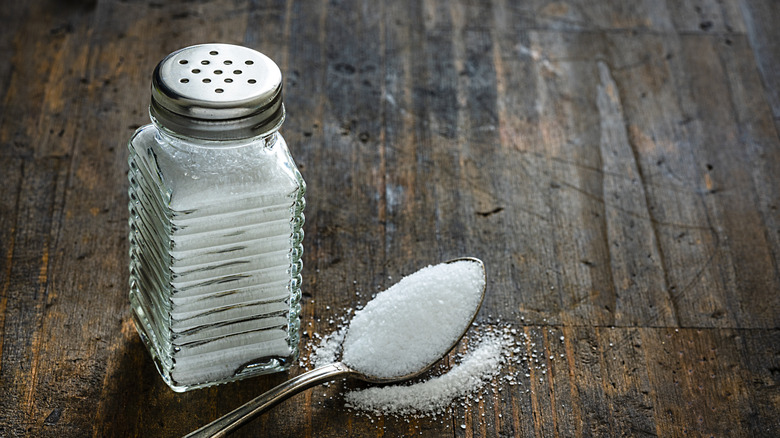 salt shaker with spoonful of salt