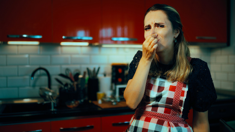 A woman unhappy with the smell in her kitchen.