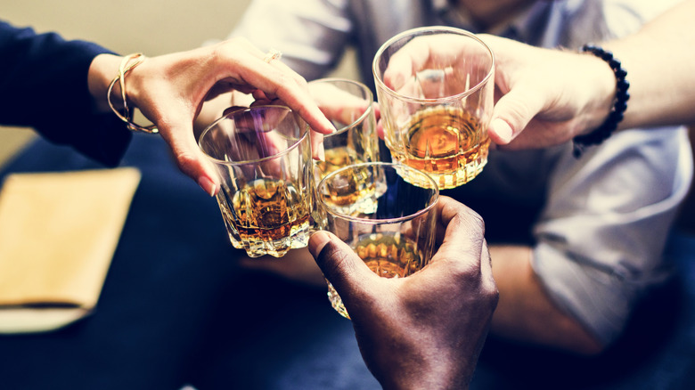 glasses with Scottish whisky being clinked together for a toast