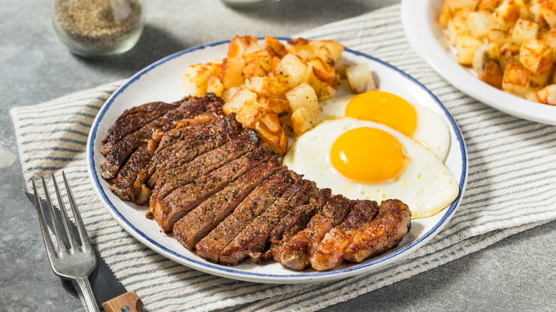 Steak and eggs on plate with hash