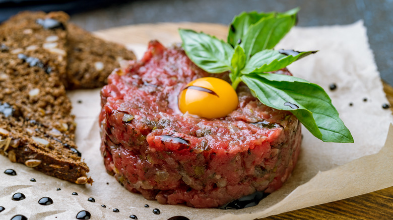 Steak tartare with yolk on top, on a plate