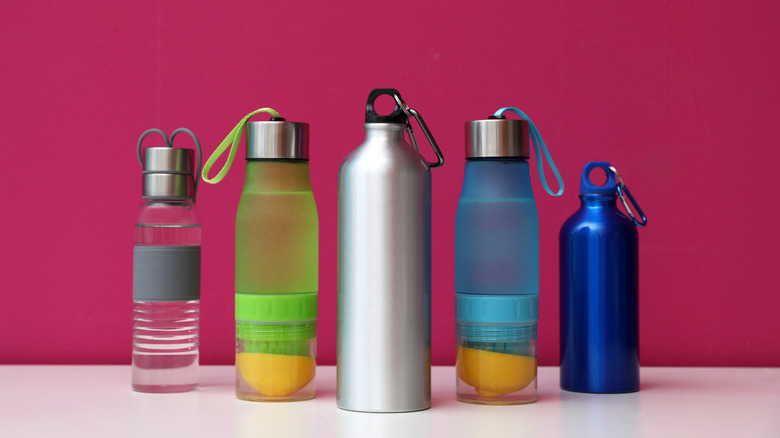 various water bottles against a pink background