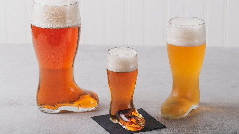Three glass German beer boots filled with beer