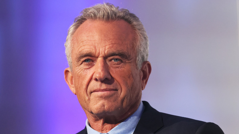 A portrait photo of Robert F. Kennedy Jr. on a purple background.
