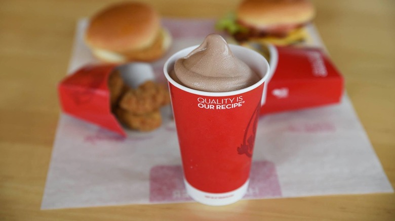 A Wendy's Chocolate Frosty in front of burgers and chicken nuggets at Wendy's