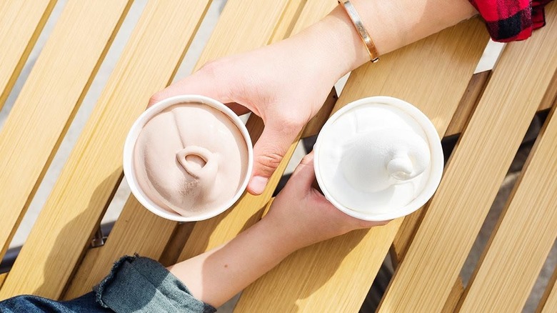 Two hands holding Wendy's Chocolate and Vanilla Frostys