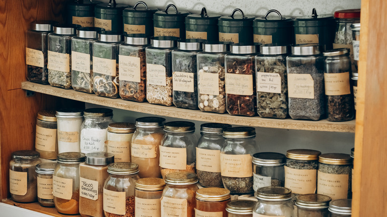 Assorted glass and metal containers arranged on wooden shelves