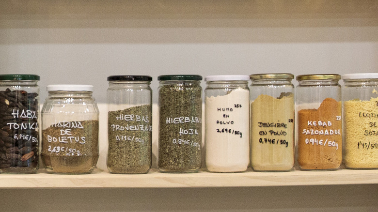 Baskets and glass jars arranged on a wooden kitchen pantry shelf