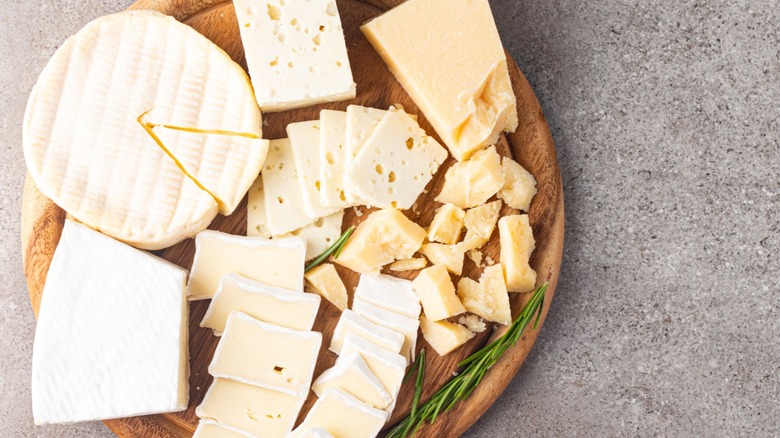 A cheese board with an assortment of five different types of cheese.