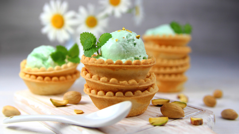 Pistachio ice cream in stacked tart shells with daisies out of focus in the background