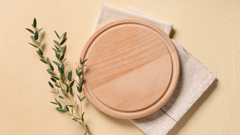 Empty round wooden cutting board on a decorative napkin