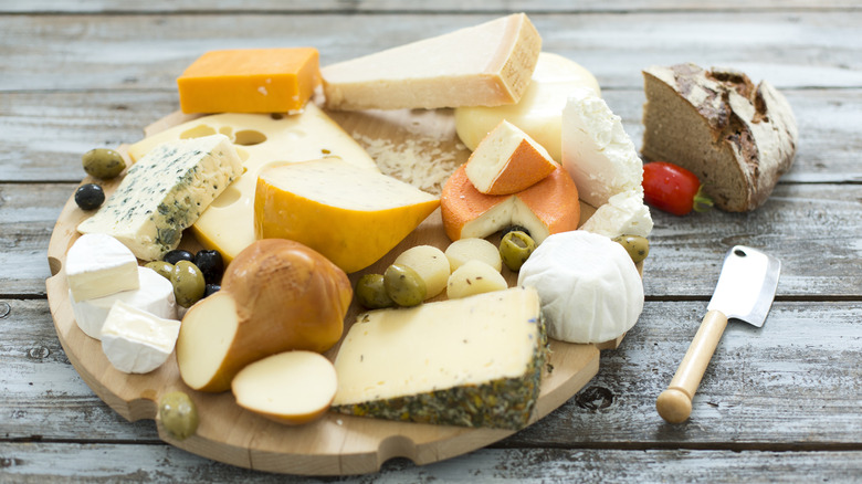 Decorative round wooden board stacked with cheese