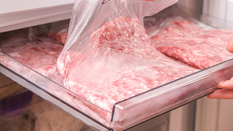 Ground beef in plastic being stored in a freezer