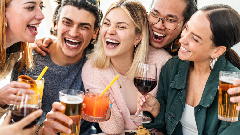 Close-up of friends holding hugging and holding drinks